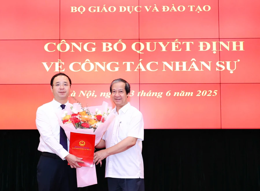 Bộ trưởng Nguyễn Kim Sơn trao Quyết định và tặng hoa chúc mừng tân Phó Vụ trưởng Vụ Giáo dục Phổ thông Nguyễn Thế Sơn.