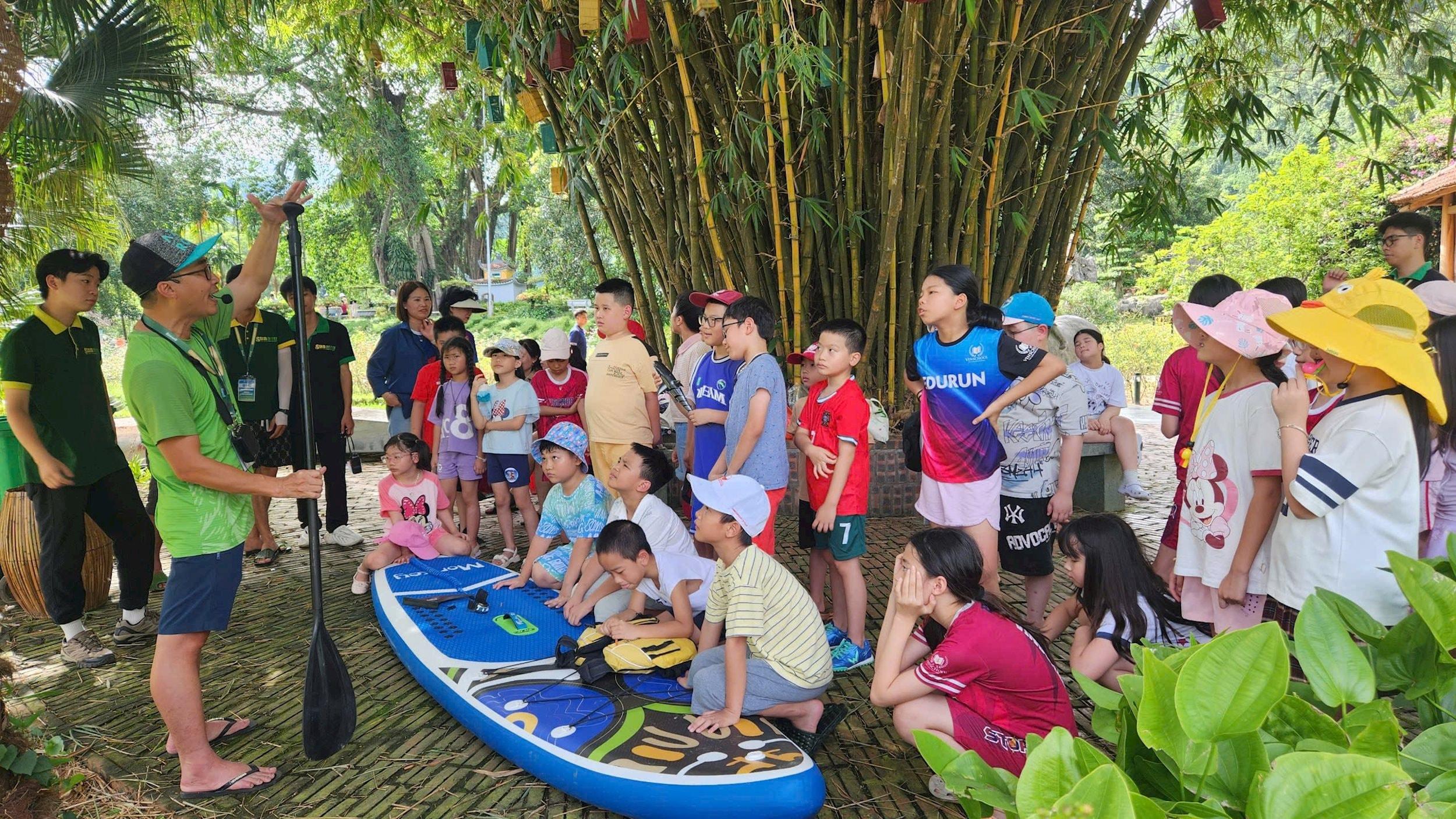 Hướng dẫn viên hướng dẫn cho học sinh học chèo sup.