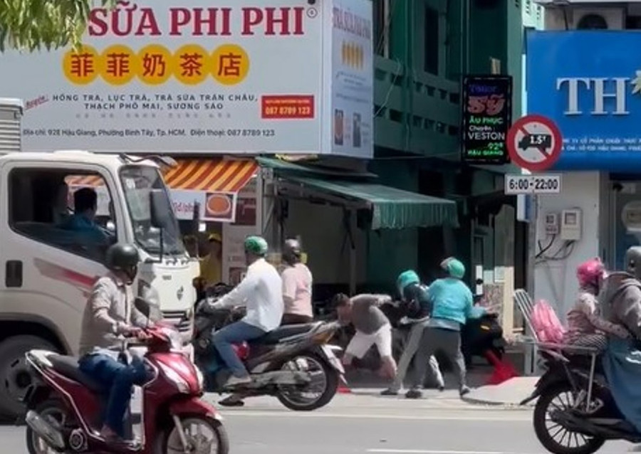 Nhóm người đánh nhau loạn xạ trên đường Hậu Giang, trong đó có một số người mặc áo xe ôm công nghệ. (Ảnh cắt từ clip)