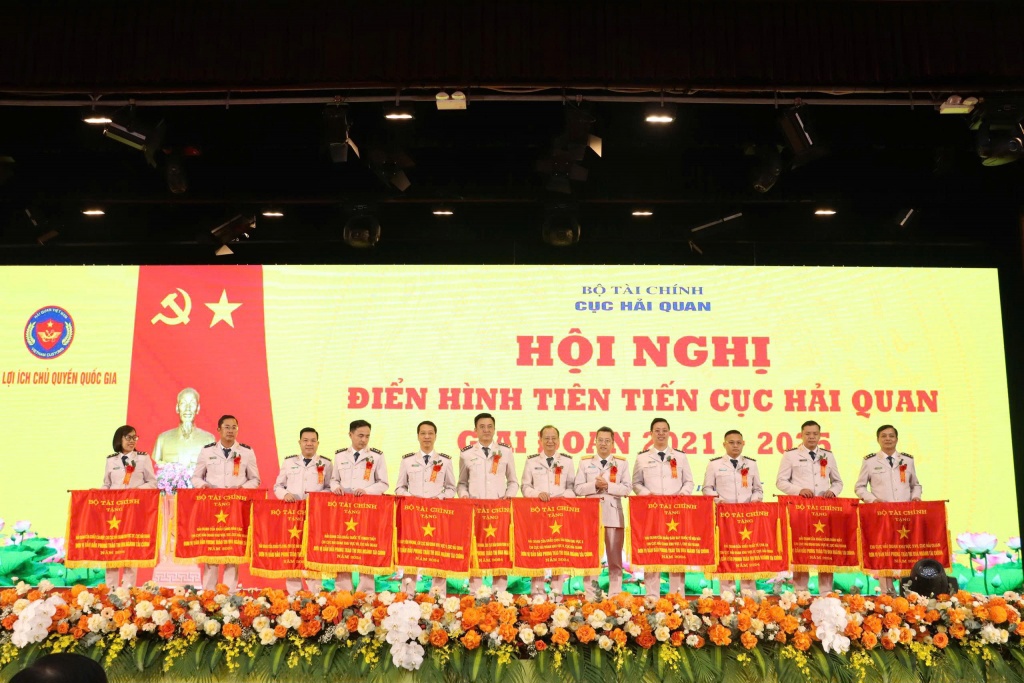 Phó Cục trưởng Cục Hải quan Âu Anh Tuấn (thứ 5 bên phải qua) thừa ủy quyền trao Cờ thi đua của Bộ Tài chính tặng 11 tập thể có thành tích xuất sắc. Ảnh: Quang Hùng.