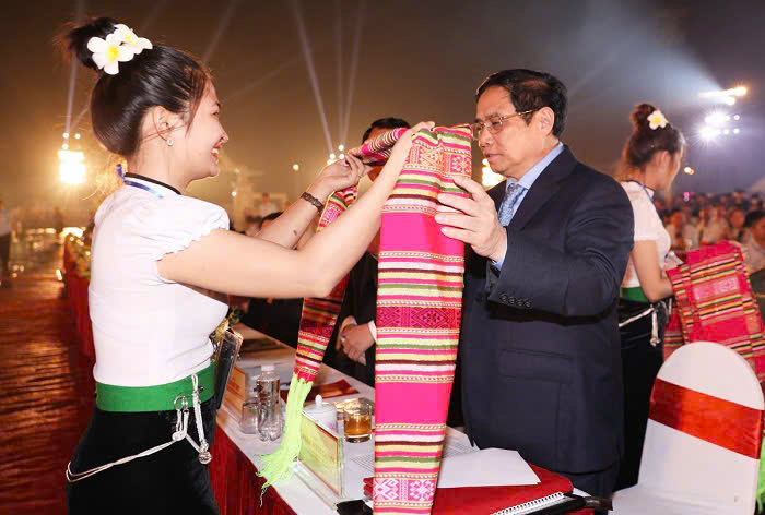 Cô gái người Thái tặng hoa Thủ tướng Phạm Minh chính tại Lễ đón nhận Bằng của UNESCO ghi danh “Nghệ thuật Xòe Thái” vào Danh sách Di sản văn hóa phi vật thể đại diện của nhân loại năm 2022. Ảnh: Báo Lào Cai.