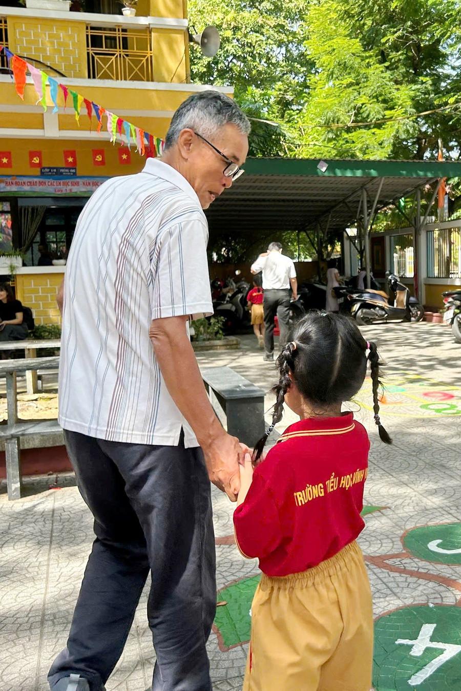 Tại Trường Tiểu học Vĩnh Ninh (phường Thuận Hóa, TP Huế), học sinh lớp 1 nắm chặt tay người thân trước khi bước vào lớp. 1.jpg