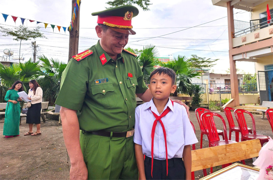 Phó Giám đốc Công an tỉnh Đắk Lắk, Đại tá Võ Duy Tuấn trò chuyện với em Thạch Chí Khang. (Ảnh: Thành Tâm) khang.jpg