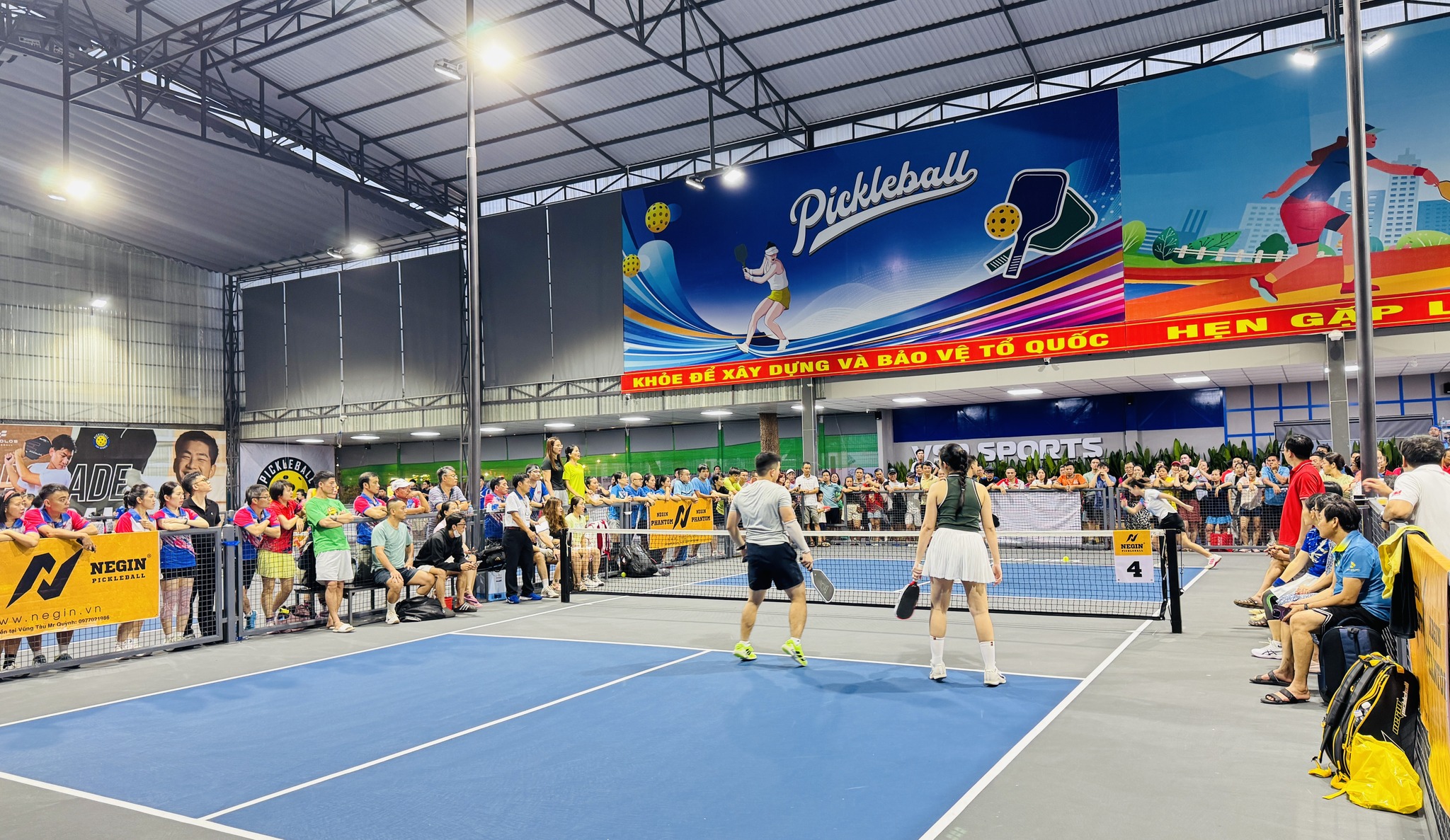 Có thể là hình ảnh về 1 người, đang chơi bóng chuyền, đang chơi tennis, bạt nhún, đám đông và văn bản