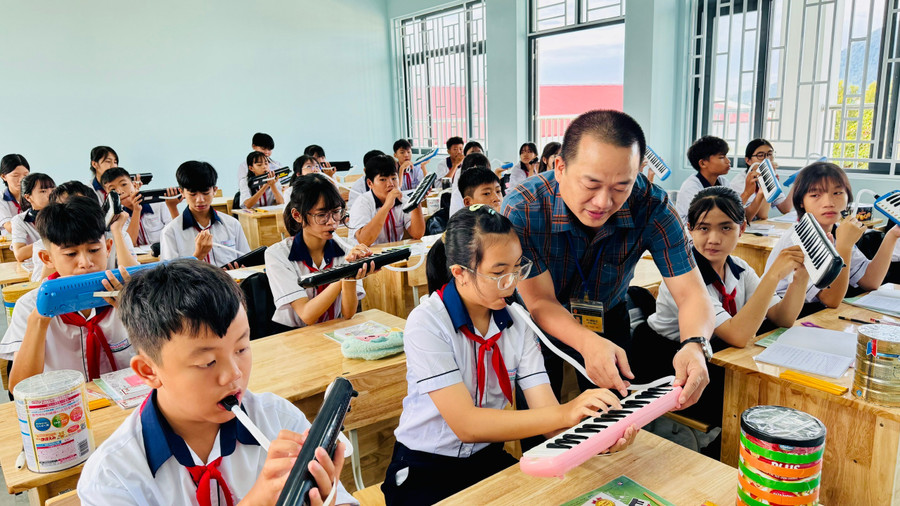 Thầy Tú hướng dẫn học sinh sử dụng kèn phím. z7114414229013-93a15ecf867dcbfb2096ef15b4152f34.jpg
