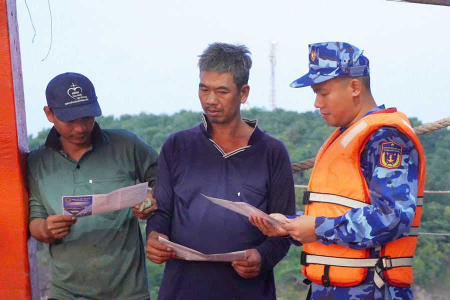 Lực lượng Cảnh sát biển tuyên truyền cho ngư dân lớn tuổi thông qua tờ rơi. Ảnh: Yến Phương canh-sat-bien-1.jpg