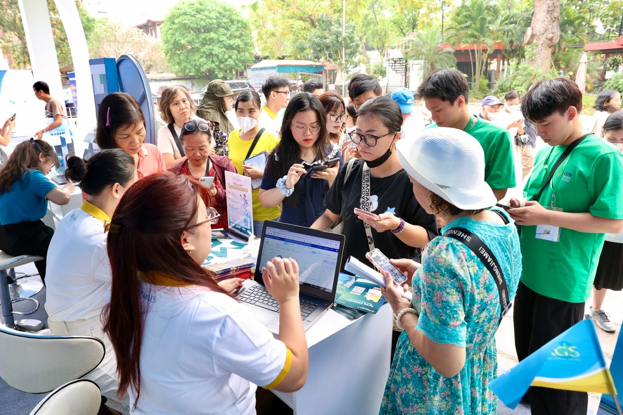 Ảnh 3 - Nhân viên Vietnam Airlines hướng dẫn khách tham quan thực hiện các thủ tục đăng ký dịch vụ tại hội chợ.
