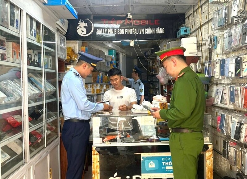 Đội QLTT số 5 phối hợp cùng Công an xã Đô Lương tiến hành kiểm tra tại hộ kinh doanh Tiệp Mobile. Ảnh: Công Tiến