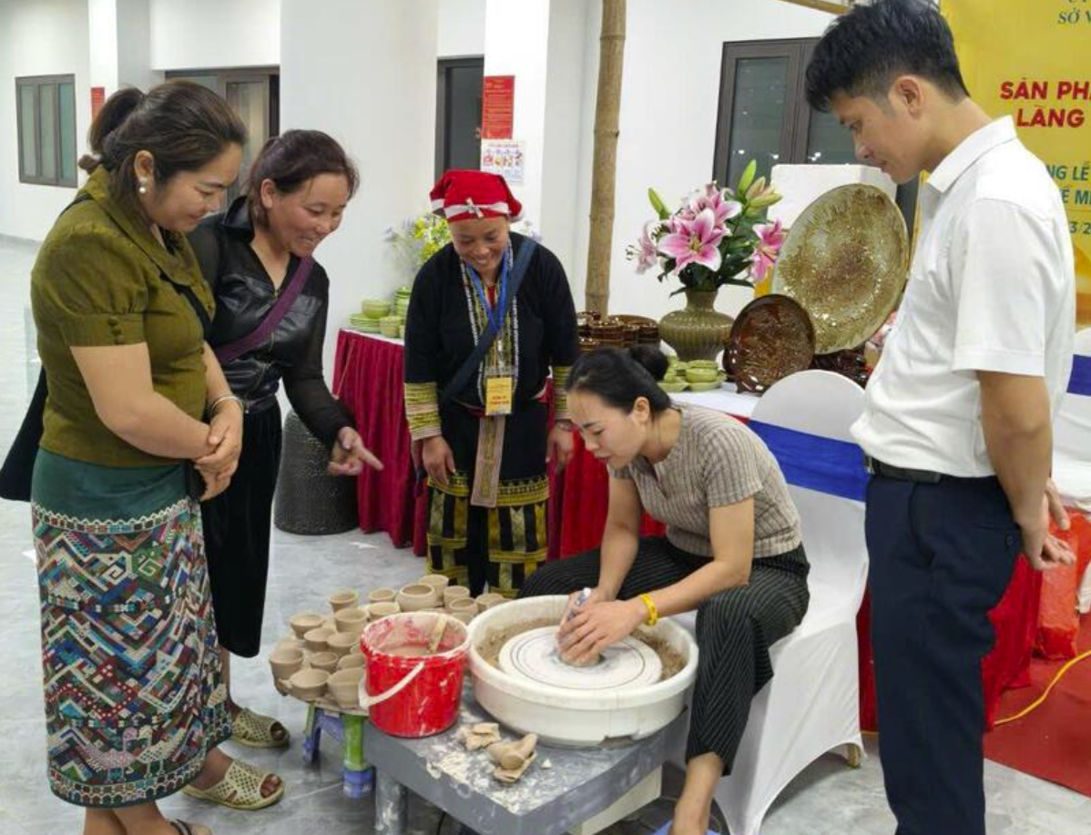 Chị Đặng Thị Tâm hướng dẫn du khách trải nghiệm nặn gốm. Ảnh: NH