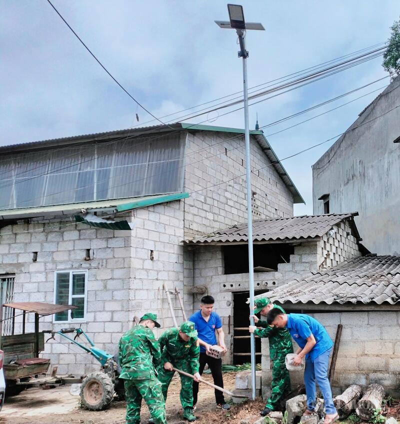 Các chiến sĩ biên phòng tỉnh Cao Bằng cùng đoàn thanh niên xã Đình Phong dựng cột đèn đường cho người dân.